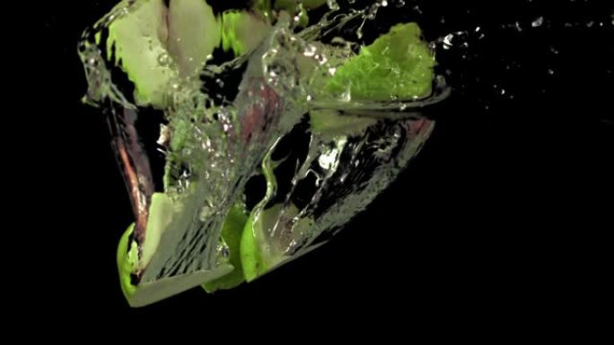 超级慢动作的梨片带着气泡落在水下。以1000 fps的高速相机拍摄。