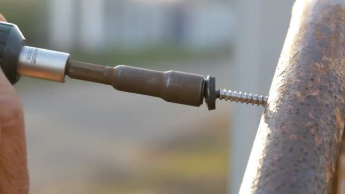 铁螺丝用手动螺丝刀拧入钢管。