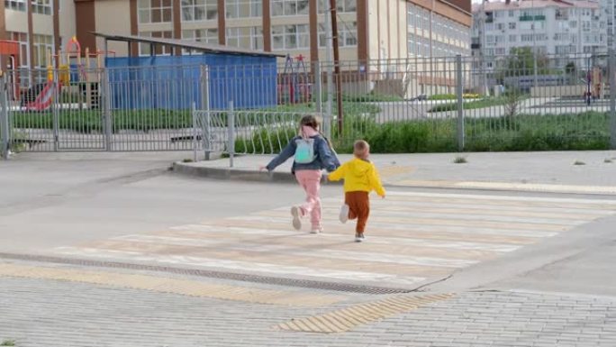 兄妹横穿人行横道。戴着医用口罩的孩子沿着通往幼儿园和学校的道路奔跑。斑马交通在城市中走道。概念行人通