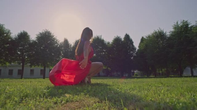 一个穿着红色长裙的女孩坐在草坪上。红色氦8K
