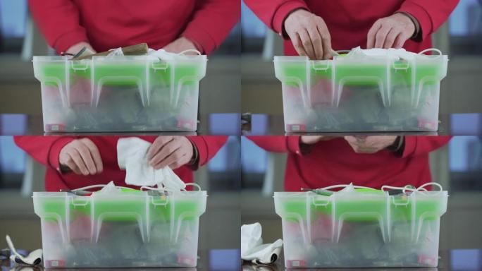 高级修理工双手打开绿色白色塑料工具箱