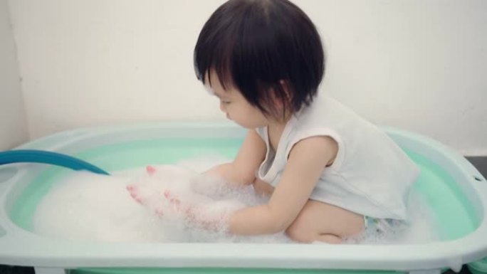 在浴缸里玩肥皂泡的女孩