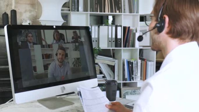 戴着耳机的自由职业者在视频会议上与同事交谈。使用计算机工作的业务团队，讨论公司的财务报告