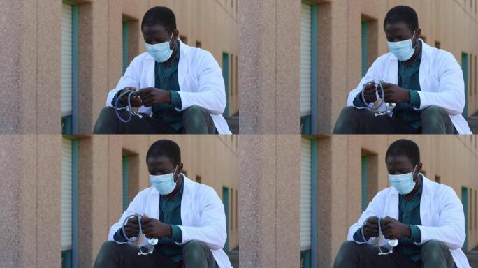 压力，劳累的黑人医生戴着口罩在休息时放松