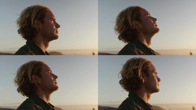 日落时，一名年轻的高加索男性在海滩上呼吸。展望未来的人。高质量4k镜头