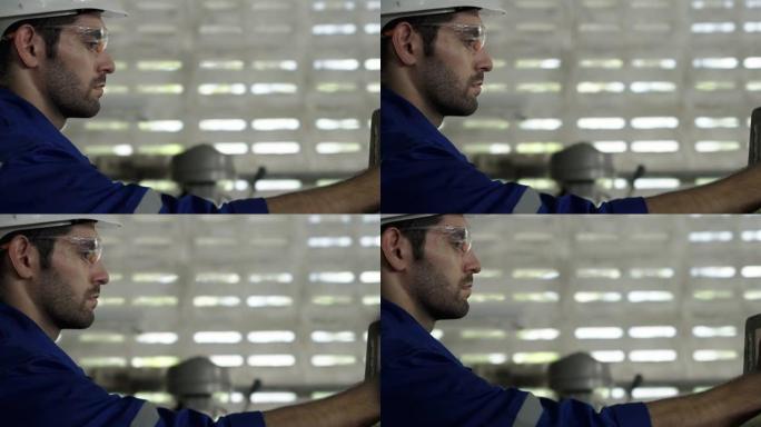 男工程师在工业机械组件中组装后检查机器的准备情况。