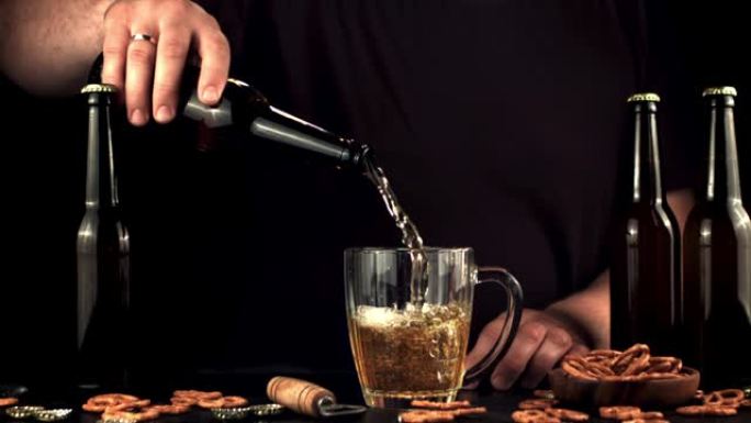 超级慢动作的男人将啤酒从瓶子里倒入玻璃杯中。以1000 fps的高速相机拍摄。
