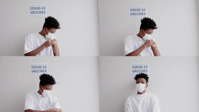 戴着口罩的非洲裔美国少年坐在医院等待新型冠状病毒肺炎疫苗接种。在诊所注射控制流行病。概念保健
