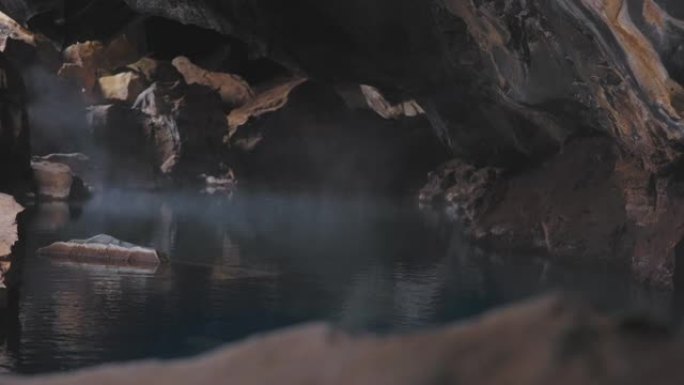 冰岛火山岩洞穴中从水池中升起的蒸汽