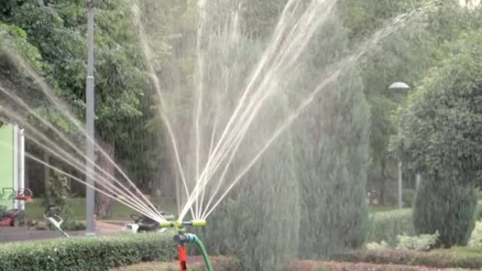 草坪灌溉系统在绿色公园工作。在炎热的天气里用水喷洒草坪。自动洒水器。自动浇水喷头浇灌草坪。智能花园