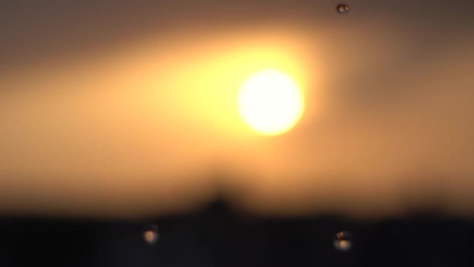 日落时落在太阳前的雨滴特写镜头