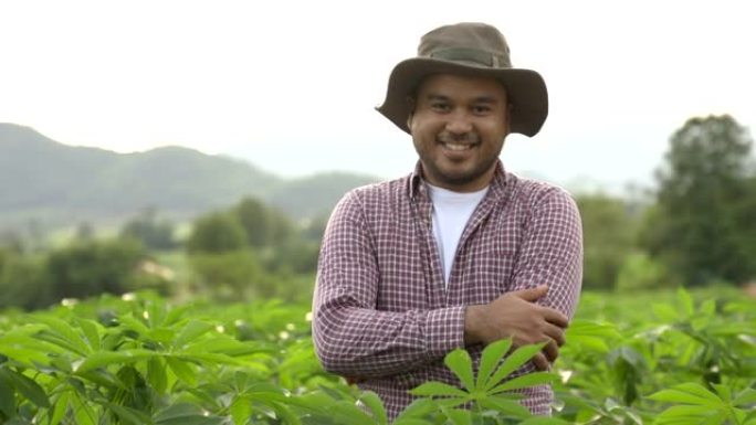日落时，戴着帽子的微笑农民站在种植园里。