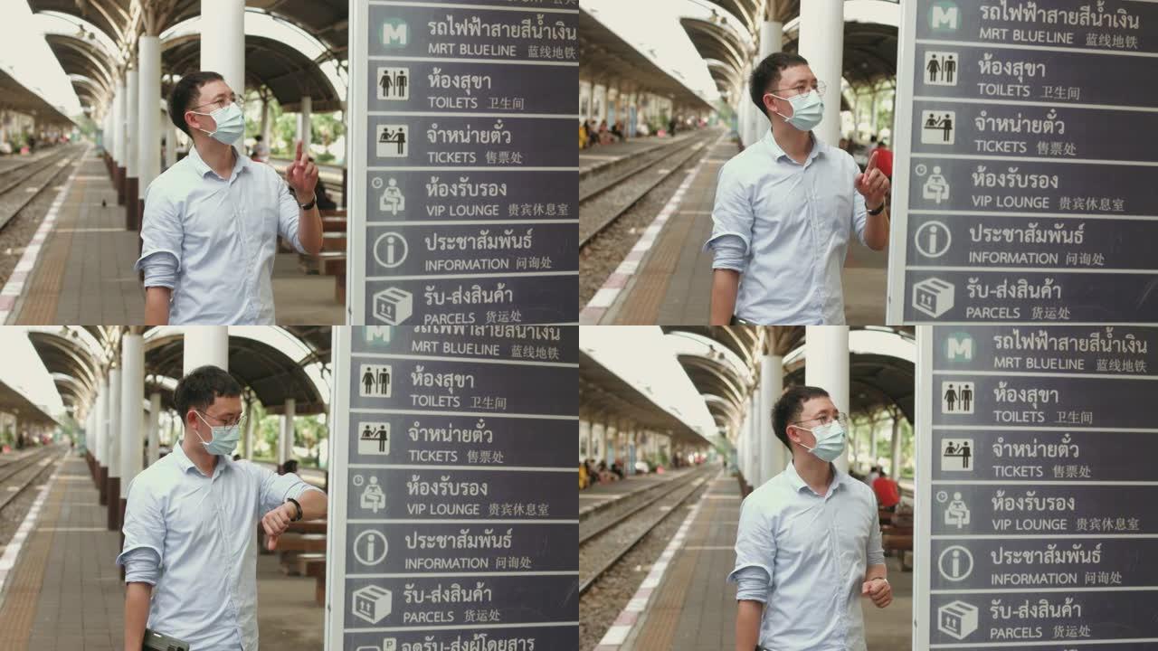 在新冠肺炎期间，一名戴口罩的亚洲男子检查到离站板等待列车