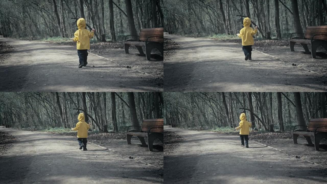 小孩子在黑暗可怕的森林里奔跑。他穿着带兜帽的黄色斗篷