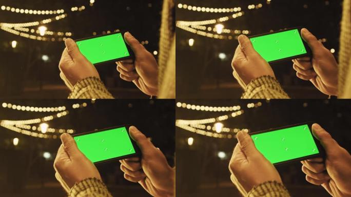手持摄像头: 使用带有绿色模拟屏幕色度键的手机的人的观点上网观看内容视频博客点击中央屏幕
