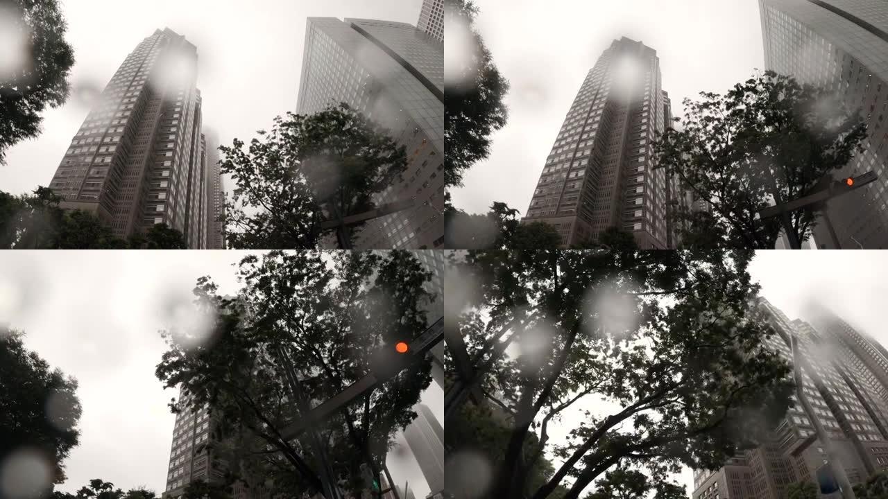 在雨天开车，仰望摩天大楼。
