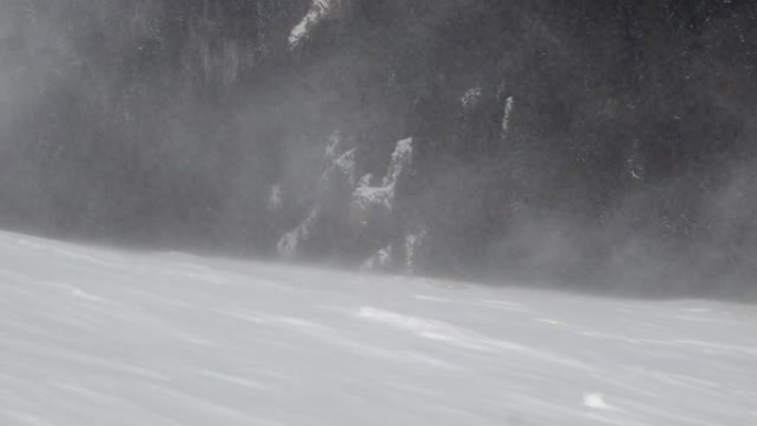 由于山顶山坡上的暴风雪，积雪在空中飘过，特写镜头