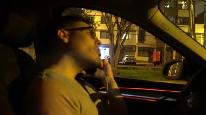 一个戴着眼镜的男人在联网的手机上聊天，晚上以4k的速度将母亲抬到车内