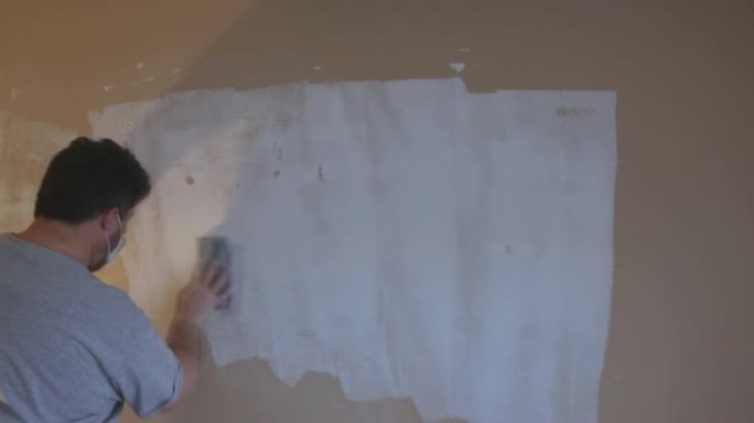男子在干墙打磨石膏石膏板