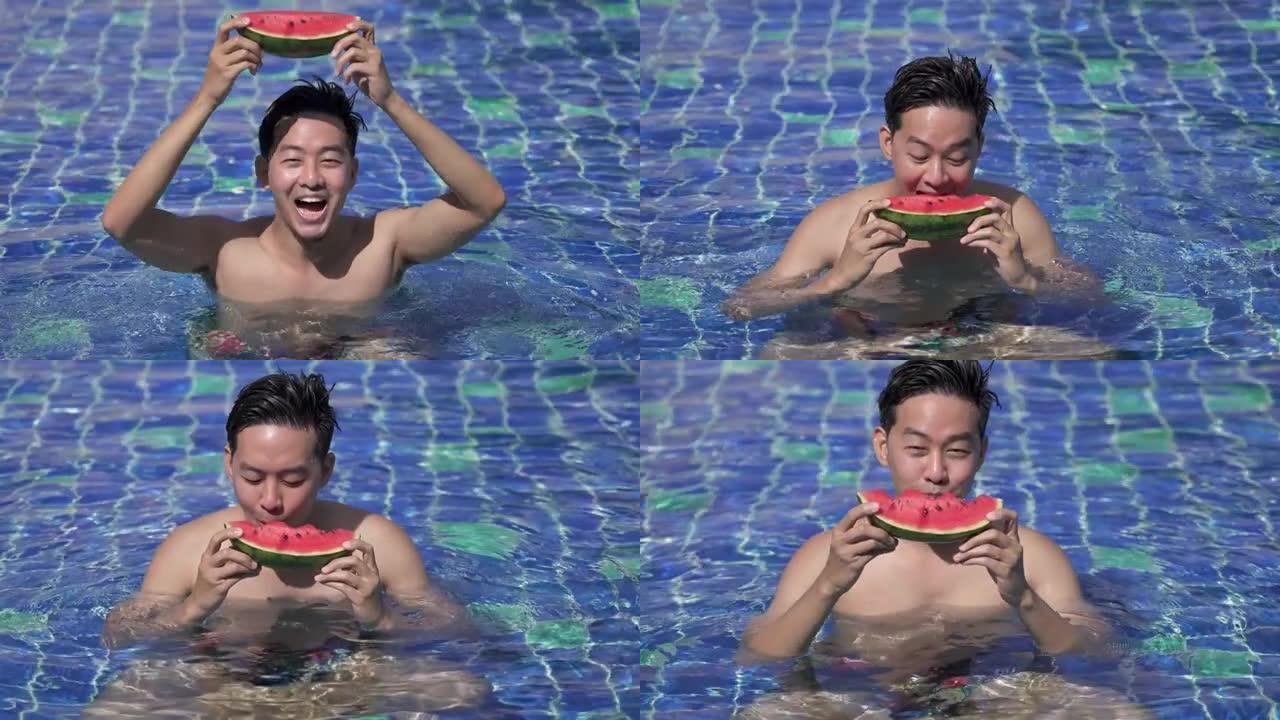 亚洲男子在游泳池里放松，手里拿着西瓜