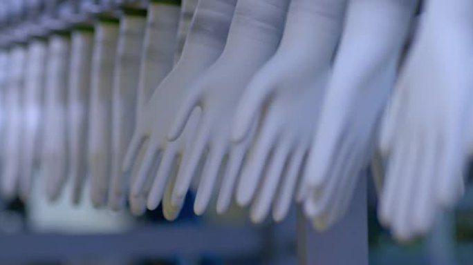 特写，橡胶手套坯料在传送带上旋转。工厂生产橡胶医用手套的现代化设备。4k，普洛雷斯