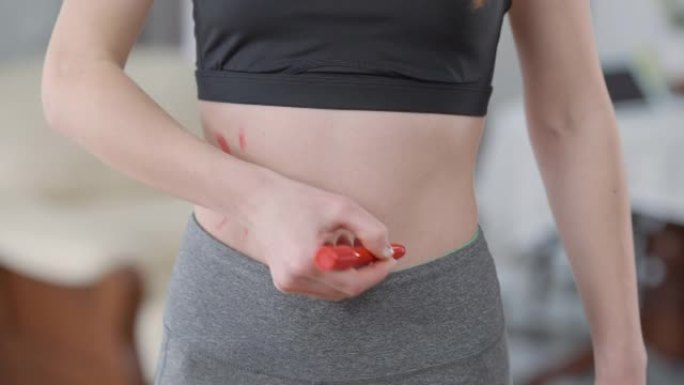 苗条的白人年轻女子的肚子用红色标记腰线。难以辨认的适合千禧一代为厌食症而努力。社会压力与女性气质概念