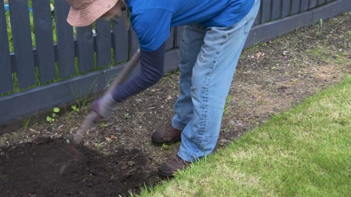活跃的退休男子在花园里翻土