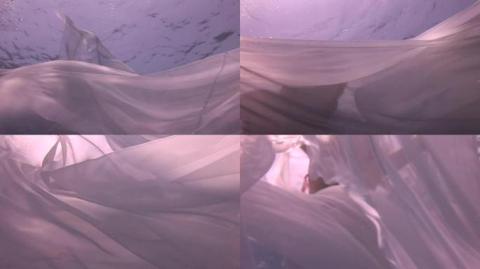 水下模型年轻女孩自由潜水员在红海的白色透明面纱。