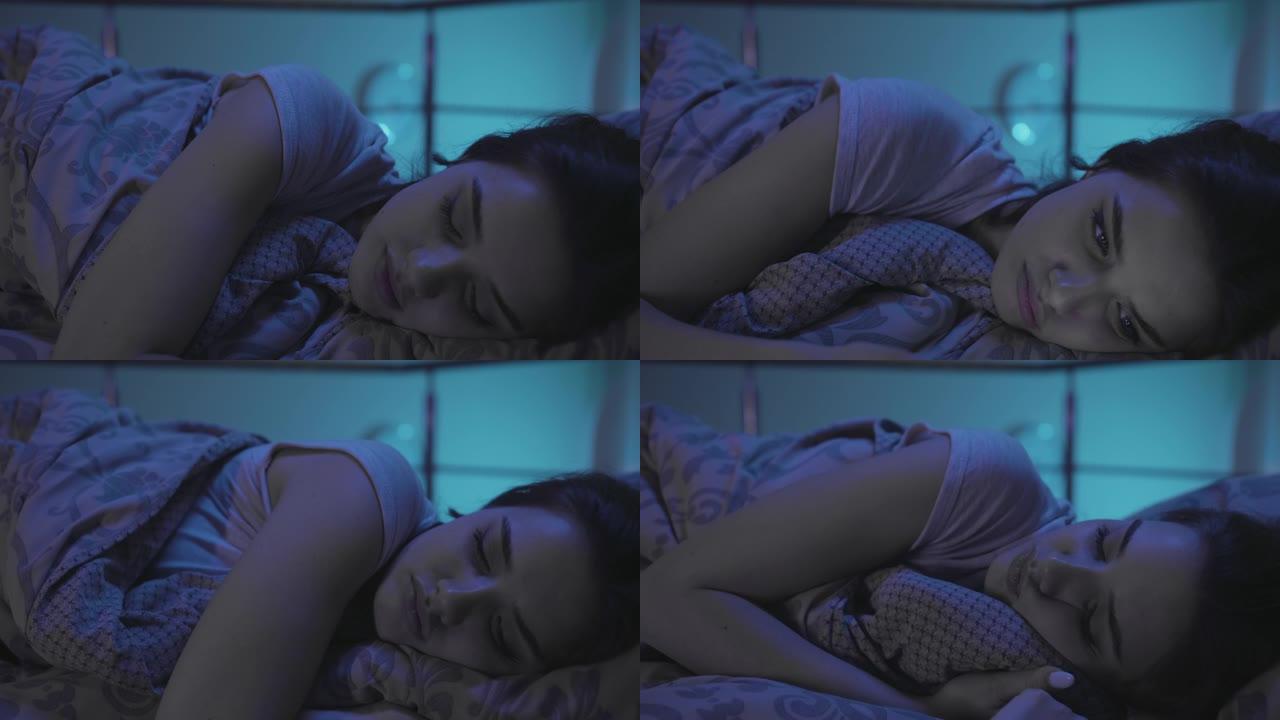 一个年轻女子晚上躺在床上，无法入睡。千禧一代妇女难以入睡