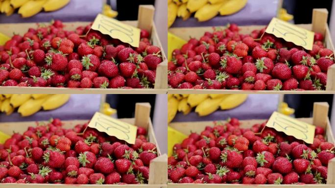 市场上板条箱中的新鲜草莓关闭