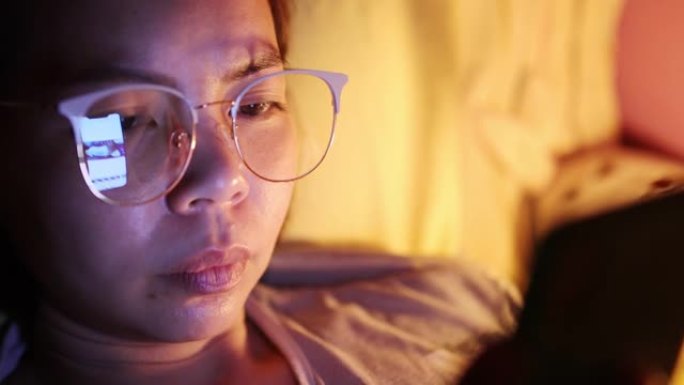 脸部特写年轻亚洲女性睡觉前发短信智能手机