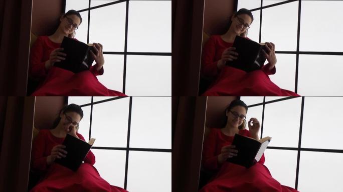 穿着红色连衣裙笑着的少女，靠窗的书