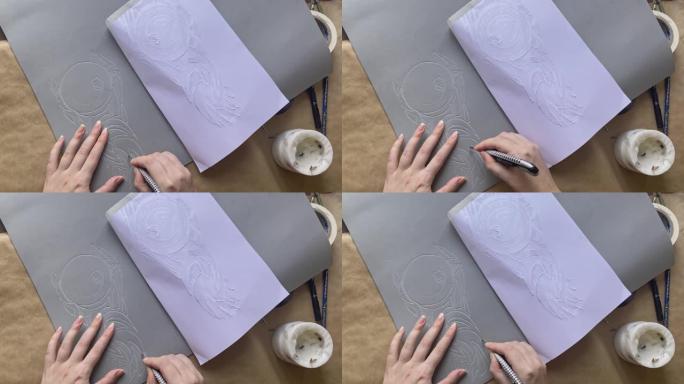妇女的手用文具刀从eva泡沫中切出图案。