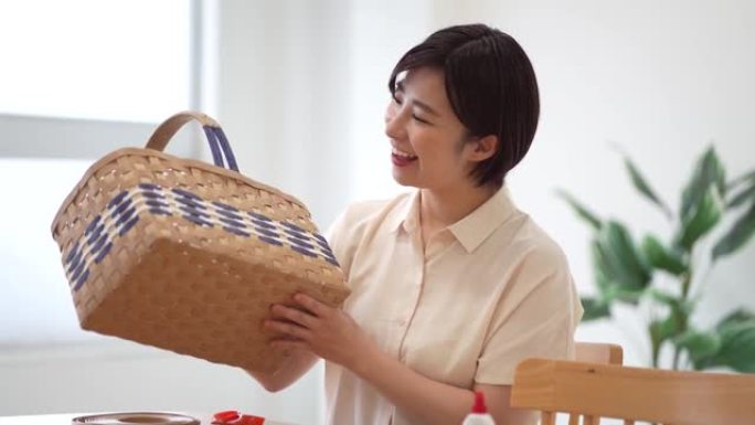 一个女人展示了一个用工艺乐队制成的篮子