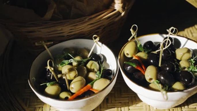 自助餐期间，自助餐桌上的橄榄和橄榄分两杯供应。人们的影子落在桌子上