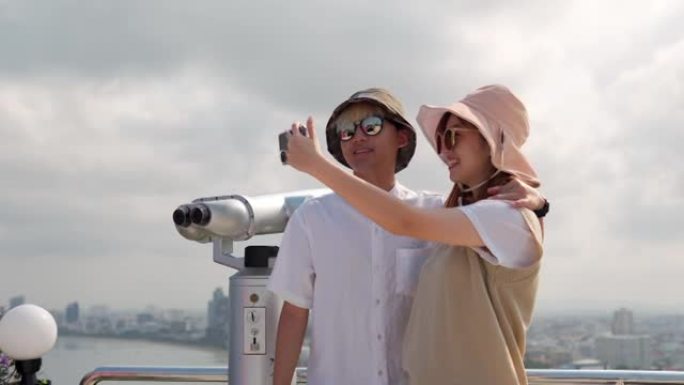 开朗的亚洲年轻夫妇游客在社交媒体上拍照。