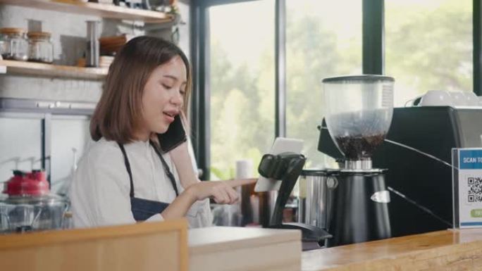 咖啡师女士咖啡机在咖啡店里接听电话并记录预订电脑