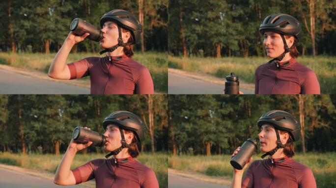 骑自行车的人在骑自行车训练时喝水。女人在硬式有氧运动中喝等渗饮料以保持水分。积极运动。自行车和铁人三