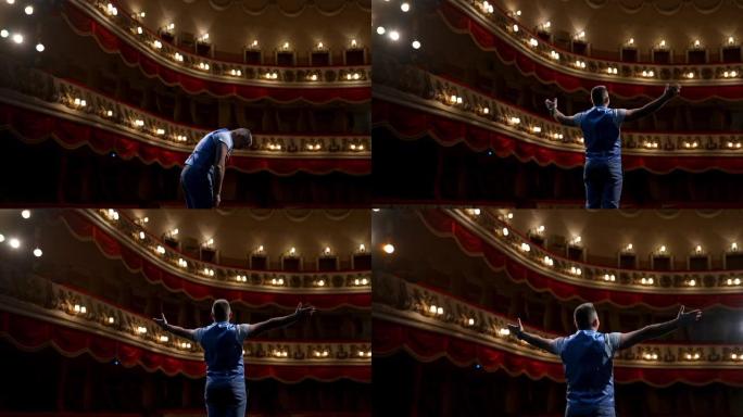 演员在戏剧舞台上鞠躬。男人站在古典剧院的现场，在空荡荡的大厅前排练时扮演自己的角色。后视图。