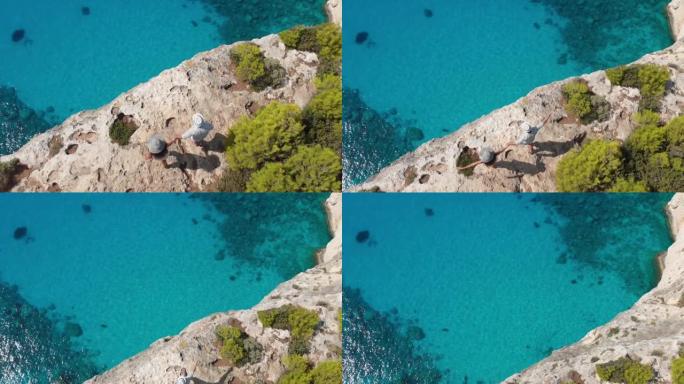 4k视频无人机视图，年轻夫妇在希腊扎金索斯悬崖周围围堵