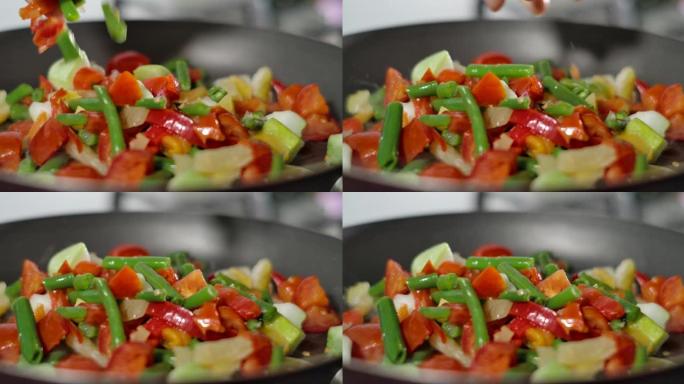 油炸有机蔬菜。将五颜六色的热气腾腾的蔬菜放在锅上混合。烹饪过程，健康食品，素食。慢动作。素食有机保健