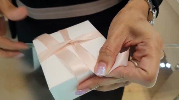 礼品包装。女人系粉色丝带蝴蝶结