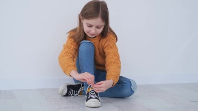 快乐的小女孩在运动鞋上系鞋带