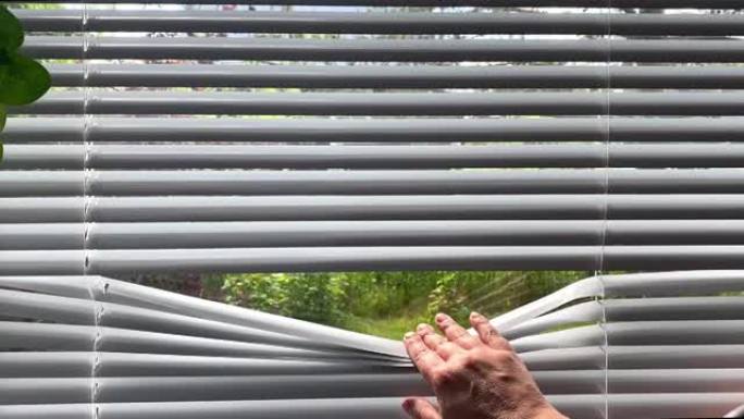 手拉开百叶窗，从外面看