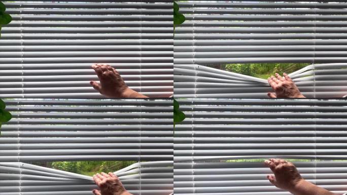 手拉开百叶窗，从外面看