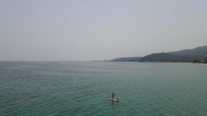 夏天，男人在海边站起来划板