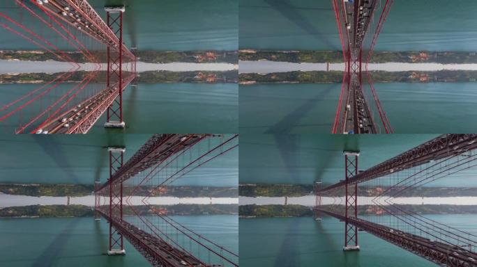 在宽阔的河流上飞过大红色吊桥的抽象超脱镜头。计算机增加了水平镜像效果。葡萄牙里斯本