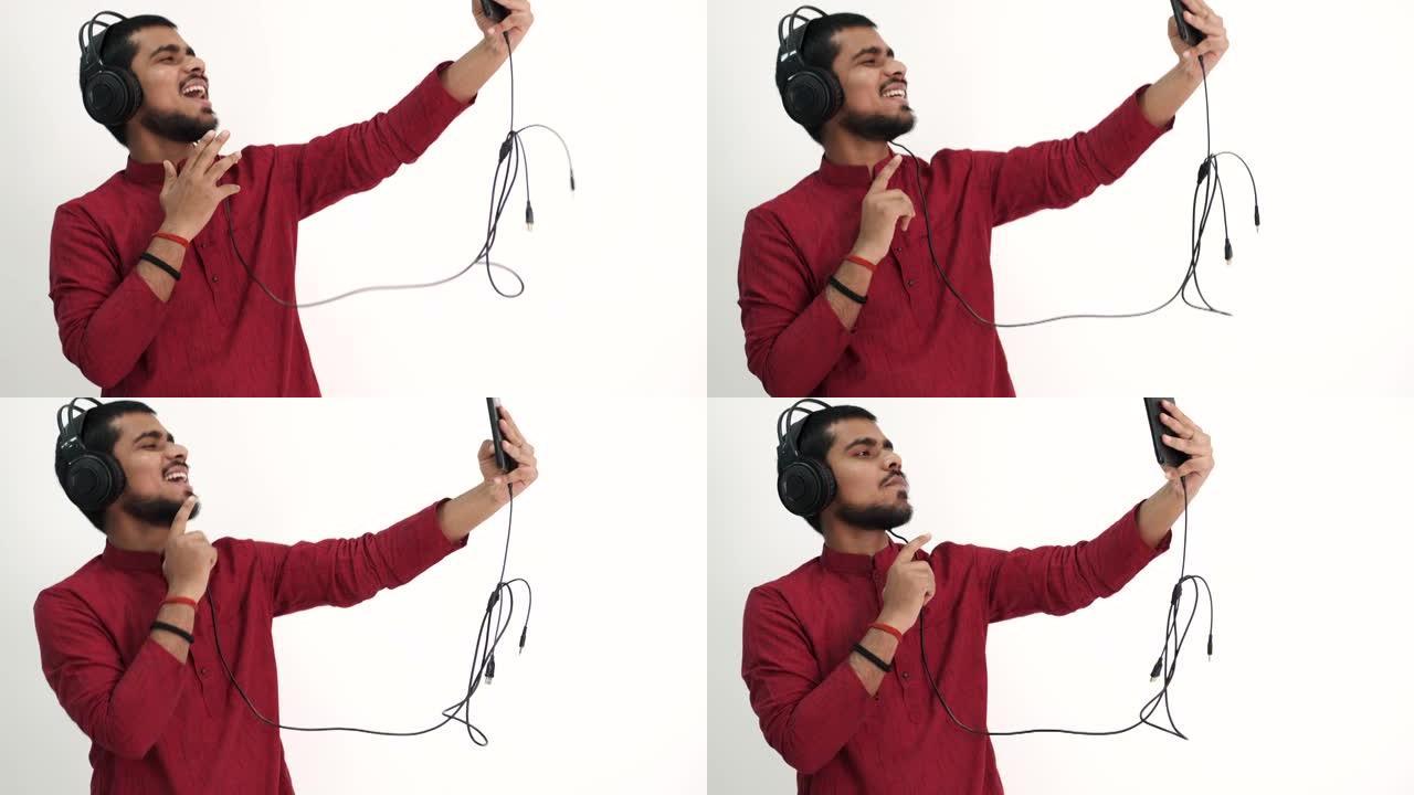 戴着耳机和平板电脑听音乐的印度男子