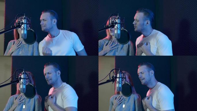 高加索男歌手在背景为五颜六色的声音录音棚里与一位女歌手热情地对唱。专业声乐录音概念的隔音室。