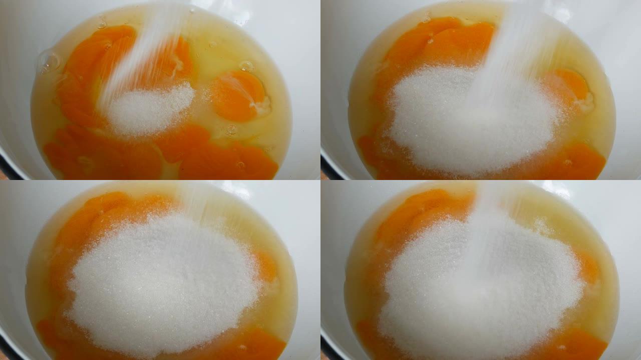 碗中的蛋黄和蛋清破裂，将糖倒在上面，以备将来生面团。